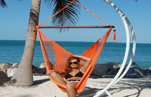Picture of a woman in a two piece bikini lying in a hammock on the beach in Los Cabos, Mexico