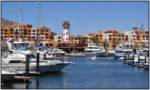 Picture of a beautiful marina in Los Cabos, Mexico.  The picture several yachts and beds moored at the marina.